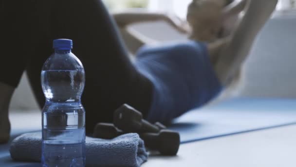 Vrouw doet sit-ups en drinkwater — Stockvideo