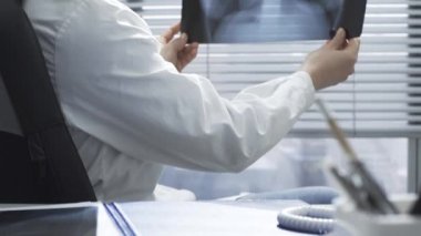 Bir hastanın röntgen görüntüsünü inceleyen profesyonel bir doktor.