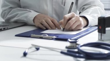 Hasta için reçete yazan kadın doktor.