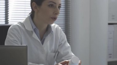 Doktor bir hastayla konuşuyor ve ilaç yazıyor.