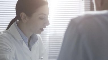 Bir hastaya tablet üzerinde radyograf gösteren bir doktor.