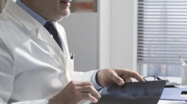 Hasta muayenehanede bir doktorla buluşup konuşuyor.