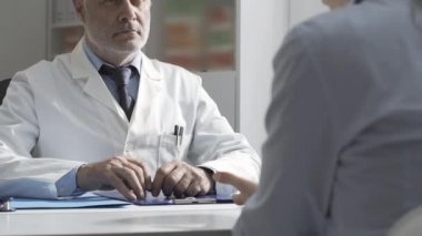 Doktor ziyaret sırasında bir hastayı dinliyor.