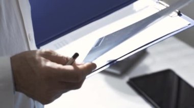 Hastanın tıbbi kayıtlarını inceleyen profesyonel bir doktor.