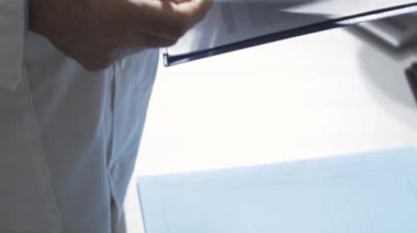 Hastanın tıbbi kayıtlarını inceleyen profesyonel bir doktor.