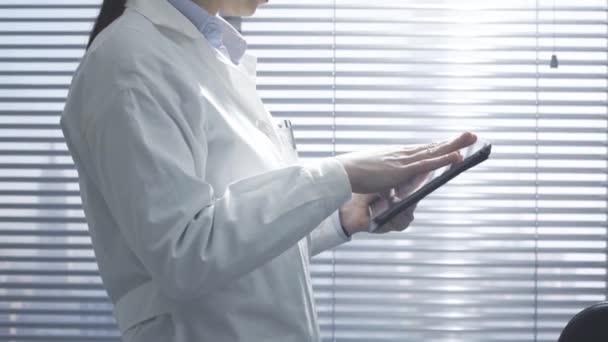 Médico profesional femenino usando una tableta digital — Vídeo de stock