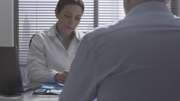 Paciente mostrando uma radiografia ao médico durante uma visita — Vídeo de Stock