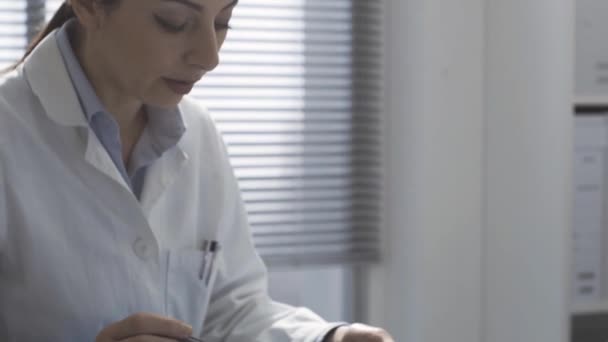 Врач показывает рентген на таблетке пациенту — стоковое видео