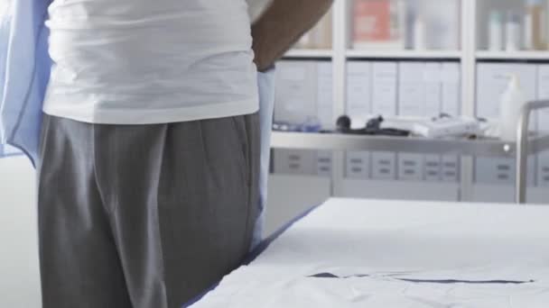 Patient trägt seine Kleidung nach ärztlicher Untersuchung — Stockvideo