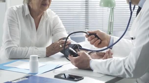 Arzt misst Blutdruck eines älteren Patienten — Stockvideo