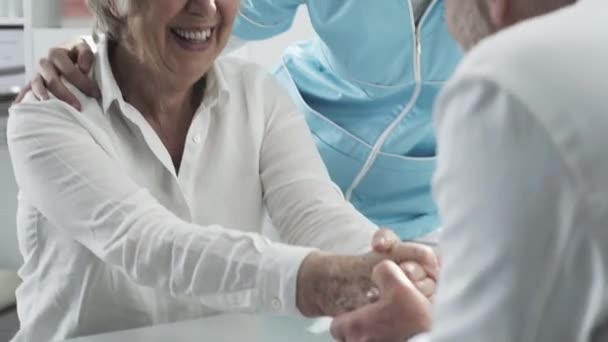 Medicinsk personal som stöder en äldre patient — Stockvideo