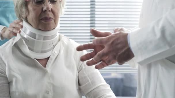 Doctor examining an injured senior woman with cervical collar — Stock Footage Doctor examining an injured senior woman with cervical collar Stock Video