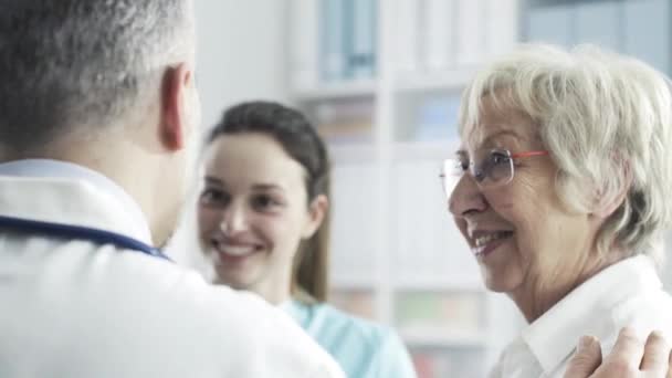 Donna anziana che parla con il personale medico della clinica — Video Stock