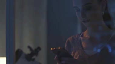 Pencerenin yanında durup sohbet eden genç bir kadın.