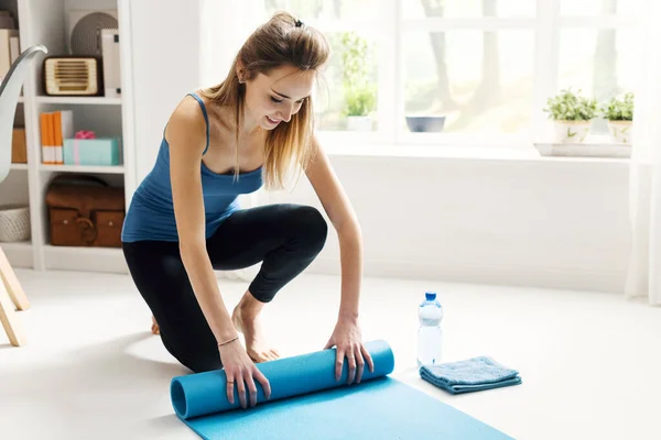 Joven Mujer Sonriente Rodando Esterilla Yoga Después Hacer Ejercicio Hacer —  Fotos de Stock