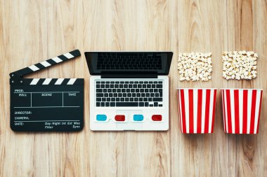 Laptop, clapper board, popcorn and 3D glasses: cinema streaming and movie series online concept clipart