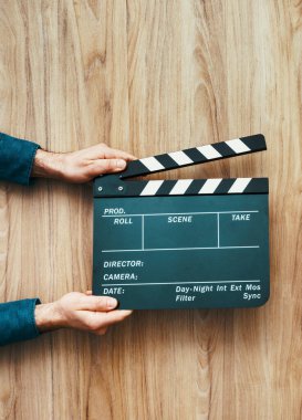 Film yönetmeninin elinde bir alkış tahtası, film yapımı ve sinema konsepti var.