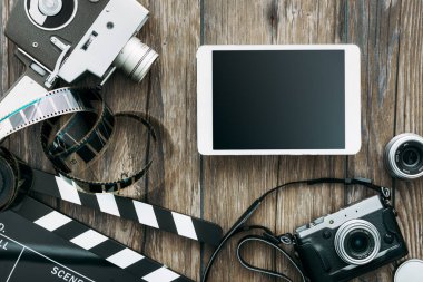 Klasik film kamerası, tablet, alkış tahtası, film şeridi ve masaüstündeki eski kamera, sinema ve video yapımı konsepti