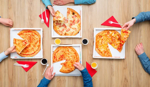 Group of friends having a pizza party at home and enjoying together, they are holding pizza slices, flat lay