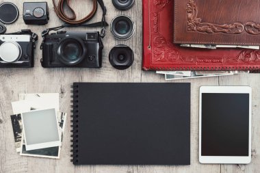 Klasik bir masaüstü, teknoloji ve yaratıcılık kavramında fotoğraf ekipmanları, kameralar, fotoğraf albümü ve dijital tablet