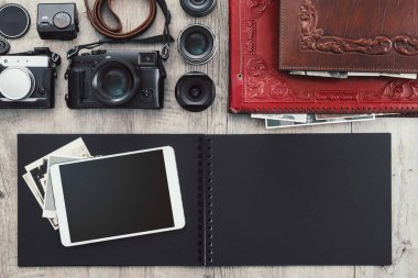 Klasik bir masaüstü, teknoloji ve yaratıcılık kavramında fotoğraf ekipmanları, kameralar, fotoğraf albümü ve dijital tablet