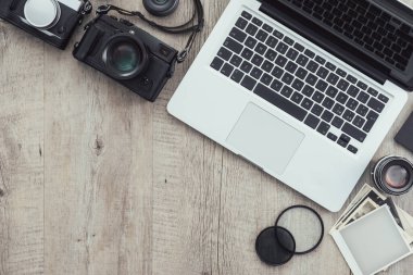 Klasik bir masaüstü, teknoloji ve yaratıcılık kavramında fotoğraf ekipmanları, kameralar, fotoğraf albümü ve dijital tablet