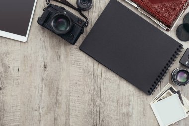 Fotoğraf ekipmanları ve kamera bir masaüstünde, bir fotoğrafçı bir resim tutuyor ve bir fotoğraf albümü yaratıyor