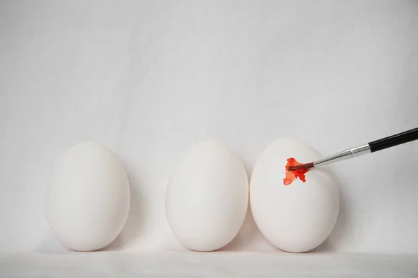 Három húsvéti tojás, és narancs ecset, festék — Stock Fotó