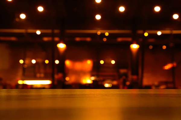 Mesa de madeira para exibição com luz borrão noite bar fundo — Fotografia de Stock