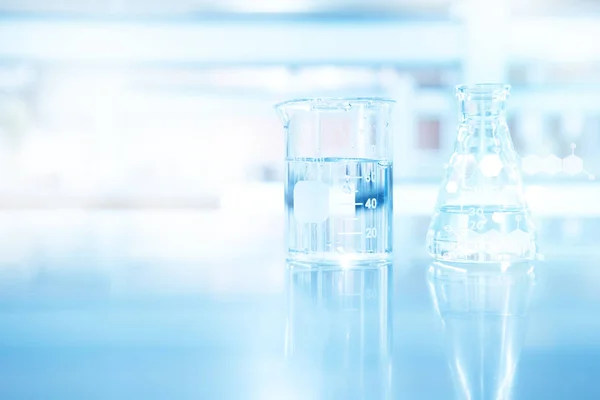 Clear blue beaker and flask and chemical structure in research s — Stock Photo, Image