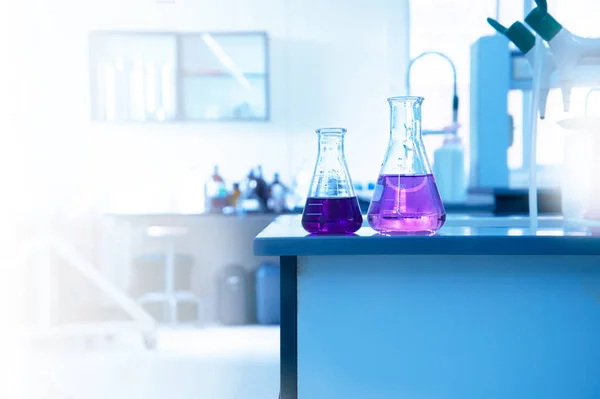 two science glass flask with purple solution on laboratory water