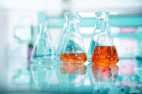 Oranje oplossing in glazen kolf bij chemische groene wetenschap en tec — Stockfoto