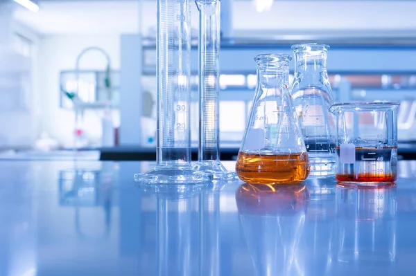 Szklana zlewka i cylinder w chemicznym niebieskim worku laboratoryjnym — Zdjęcie stockowe