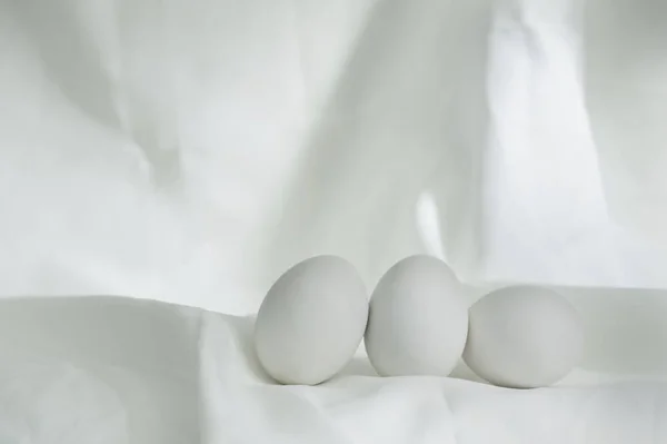 Három tojás élelmiszer fehér szövet klasszikus csendélet backgro — Stock Fotó