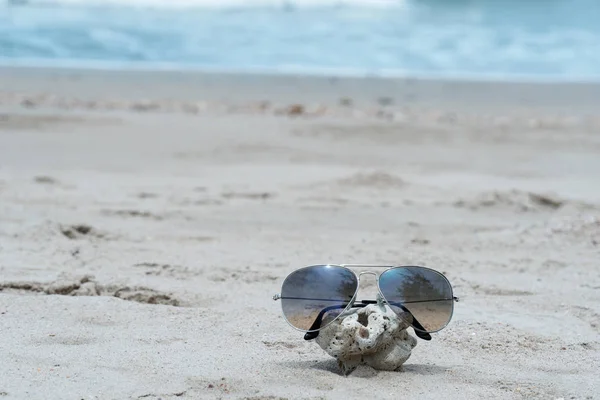 Letnie okulary przeciwsłoneczne na plaży z niebieską wodą morską podróży backgro — Zdjęcie stockowe