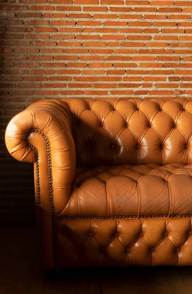 Brązowa skórzana sofa z czerwonej cegły ściany wewnątrz przytulne tło — Zdjęcie stockowe
