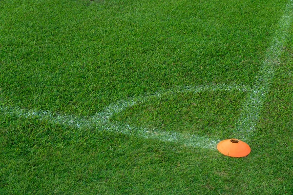 Угол зеленого футбольного поля с апельсиновой смолой для тренировки ба — стоковое фото