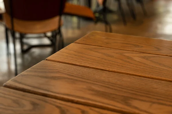 Parte superior de la mesa de madera marrón en el fondo de restaurante o cafetería —  Fotos de Stock