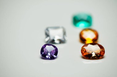 Beyaz moda arka planında parlak mor turuncu mücevher.