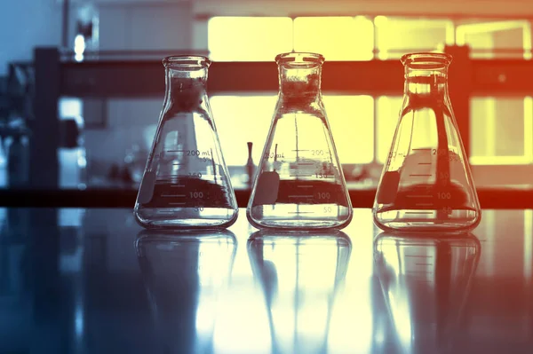 Trzy Szklanki Kolby Chemii Badania Naukowe Laboratorium Niebieskie Tło — Zdjęcie stockowe