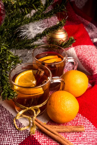 Çay portakal, portakal, ekose kareli, yeni yılda bir Noel ağacı arka plan üzerine tarçın ile