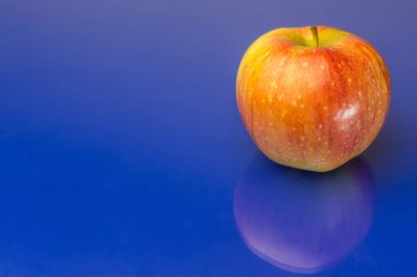 Ayna mavi arka plan üzerinde kırmızı elma