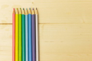 Hafif ahşap arkaplanda renkli kalemler