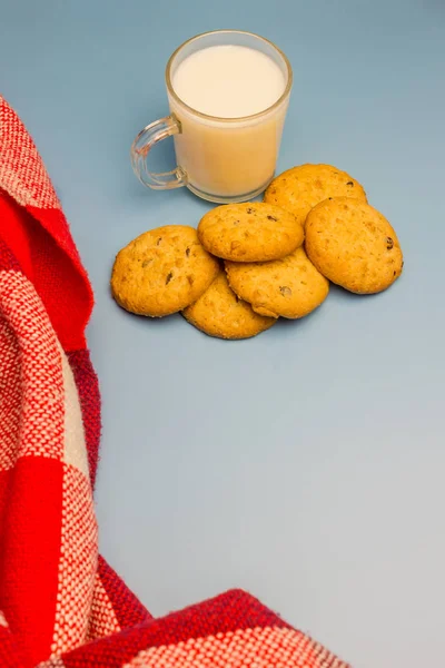 Biscotti con gocce di cioccolato e latte su sfondo blu — Foto Stock