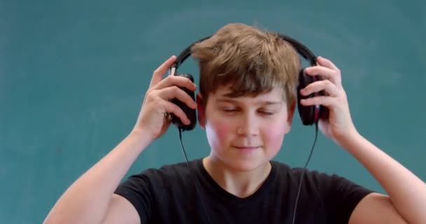 Gelukkig Kleine Jongen Luisteren Muziek Zwarte Hoofdtelefoon Dansen Groene Achtergrond — Stockvideo