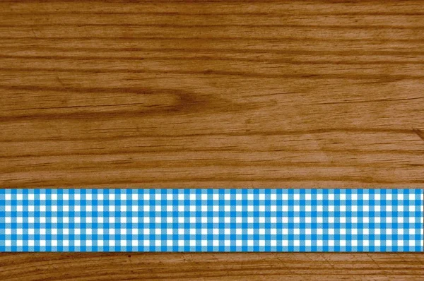 Bílá modrý kostkovaný ubrus na dřevěné prkno — Stock fotografie