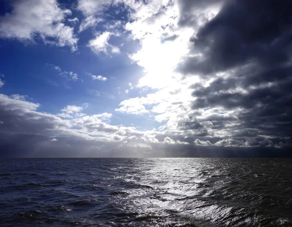 Blue sky and black clouds at sea