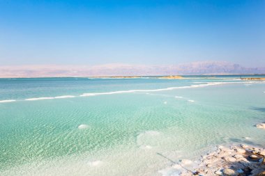Ölü Deniz sahili manzarası. Gün batımında tuz kristalleri. Ölü denizin dokusu. Tuzlu deniz kıyısı
