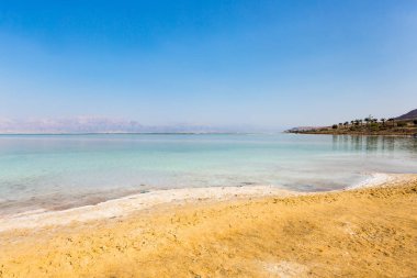 Ölü Deniz sahili manzarası. Gün batımında tuz kristalleri. Ölü denizin dokusu. Tuzlu deniz kıyısı
