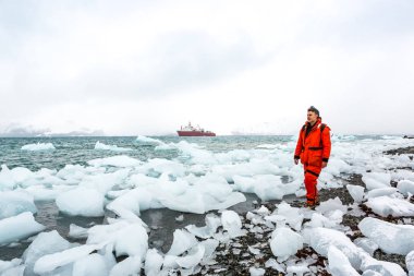 Adam buz ve Antarktika karda yürür. Buzdağları ve her şey etrafında donmuş. Soğuk.